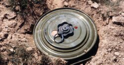 Ukrainian man moves a landmine by hand