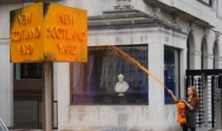 Sign at Scotland Yard sprayed with orange paint by protesters